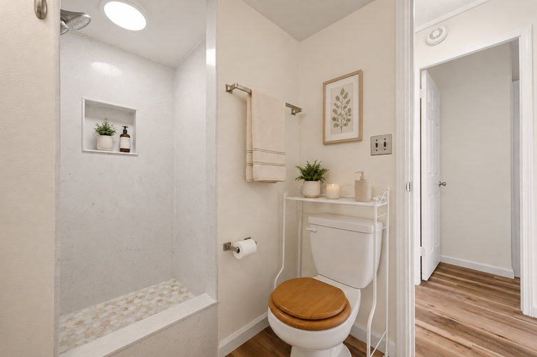 Bathroom shower with pebble floor, toilet and towel rack