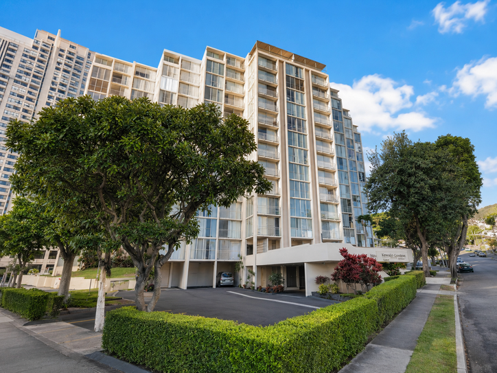 Exterior of Hale O Kalani Towers framed by lush trees