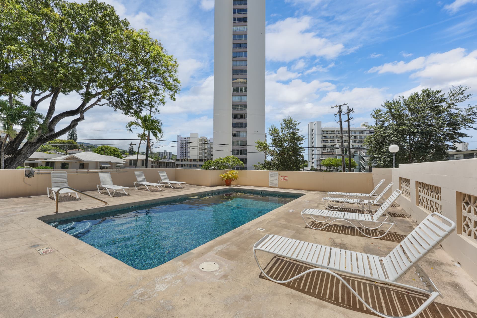 Community pool with lounge chairs and mountain view